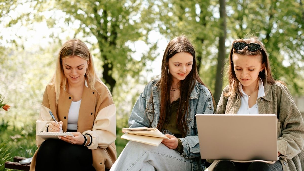 Djevojke uče u prirodi, koriste bilježnice, blokove, laptop, sretne su