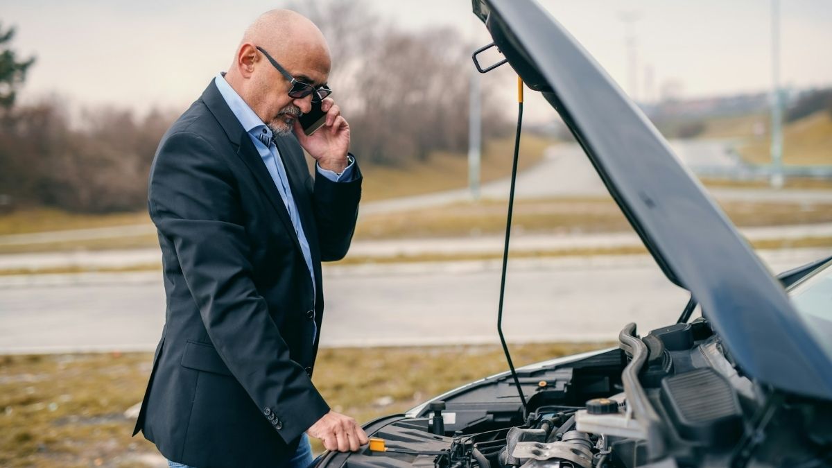 Auto se pokvario, vozač gleda u mašinu i zove vučnu službu