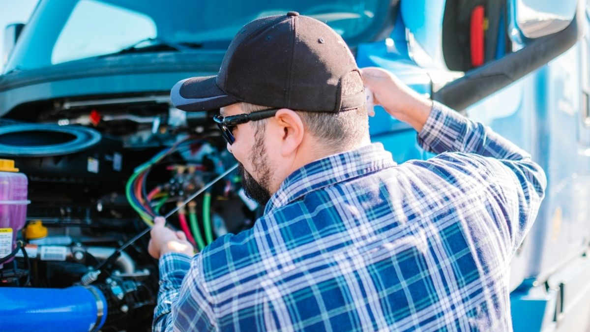 Tehničar pregledava vozilo, pomaže kod problema s automobilom u prometu