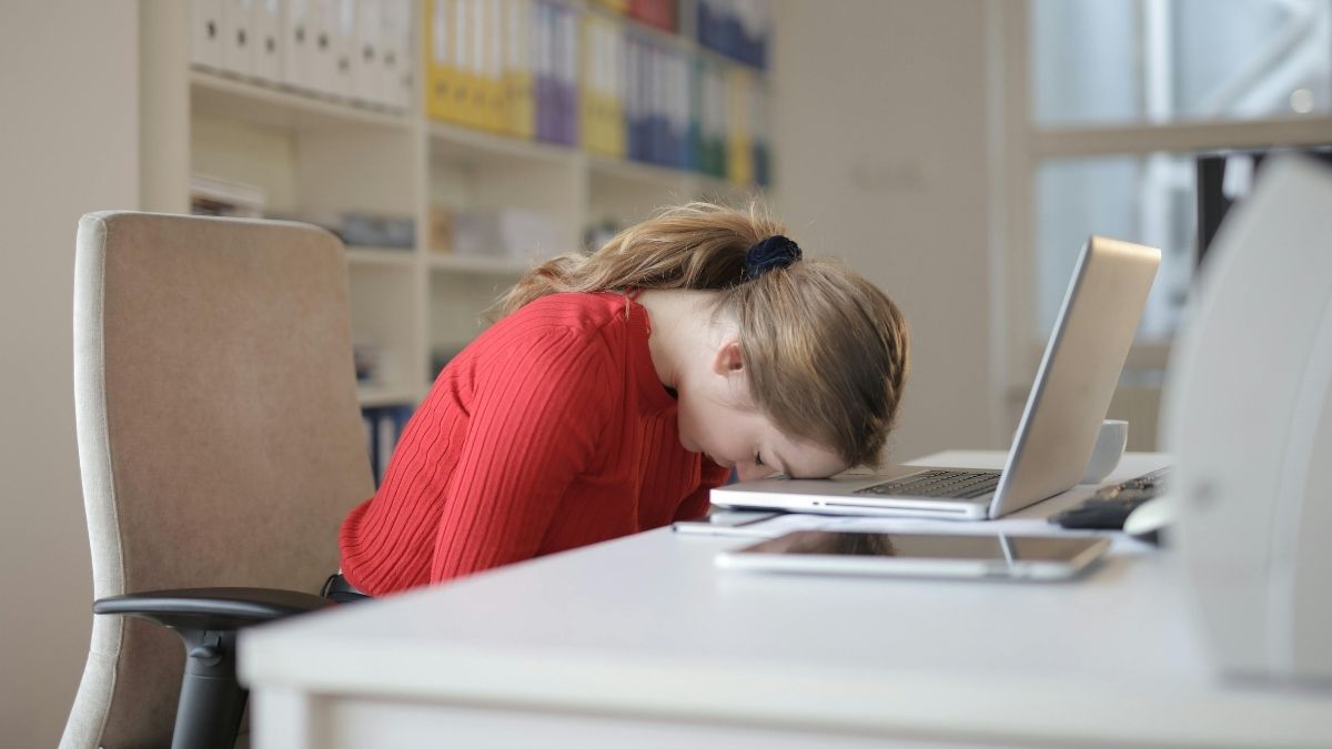 Loši odnosi na poslu, žena leži, glava na laptopu Pexels